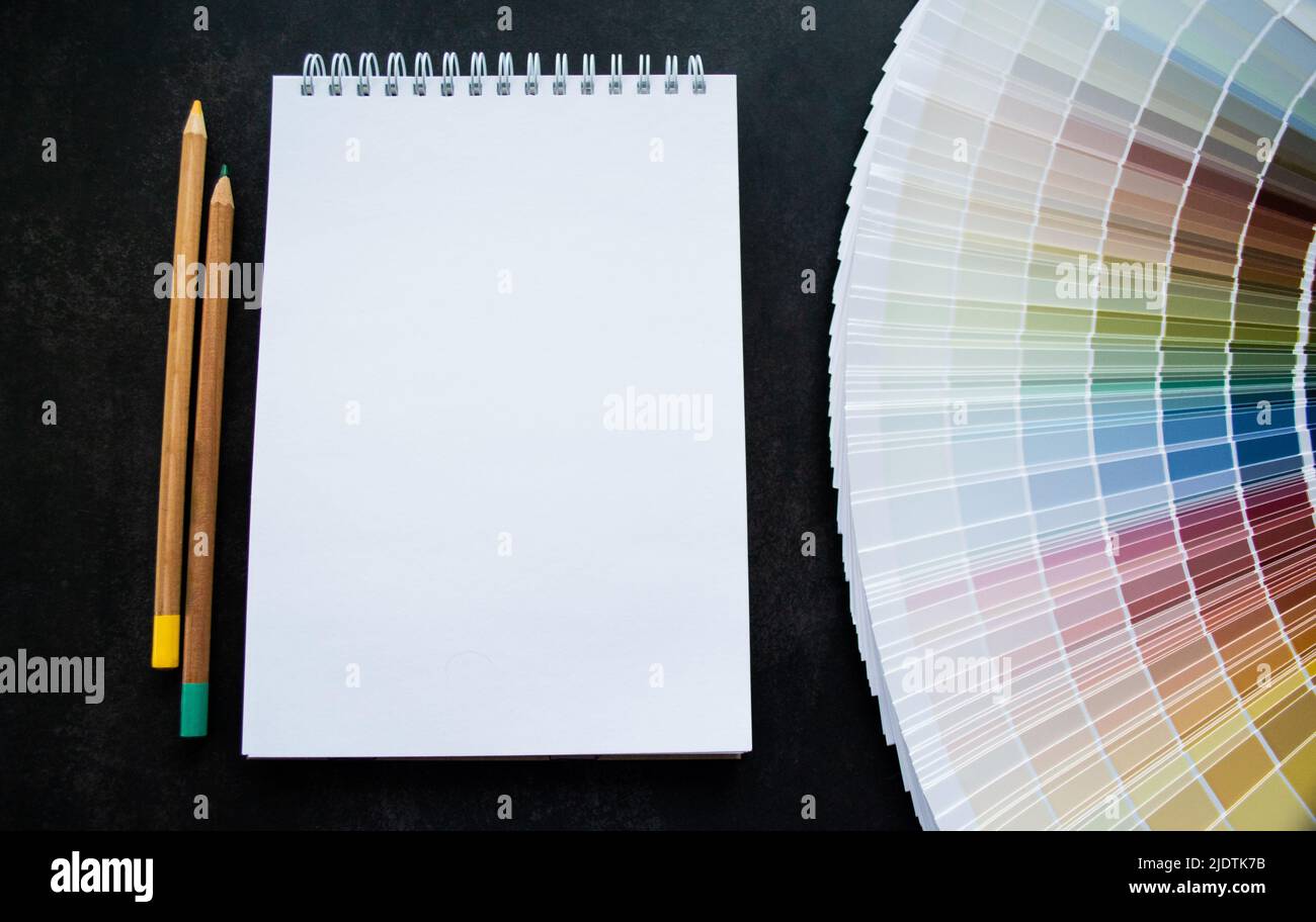 Esempi di pittura a ventaglio per interni. Colori naturali multicolore. Sfondo nero, notebook bianco per spazio di copia e matite. Foto Stock