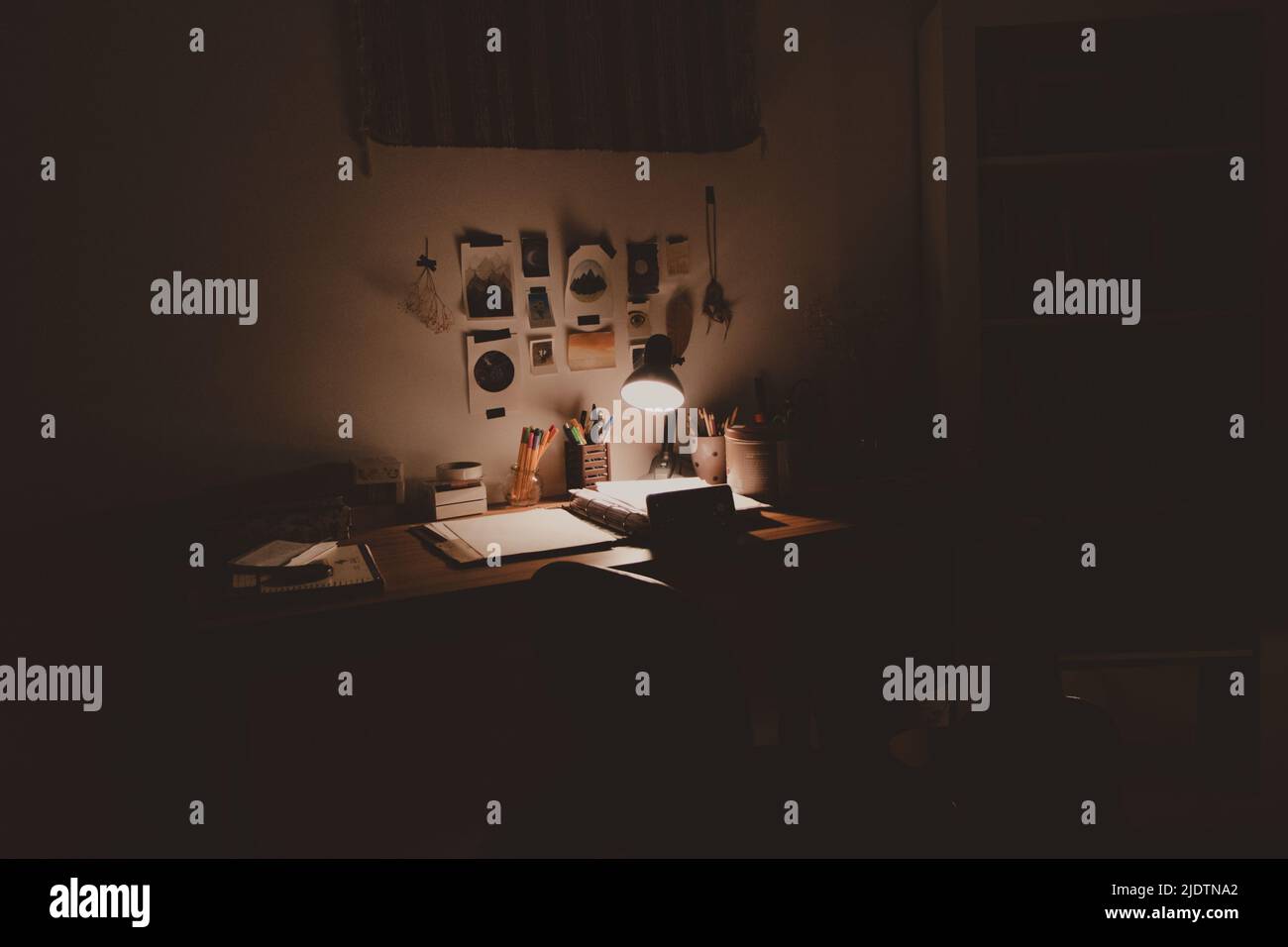 la scrivania era triste e disordinata e la luce del riflettore era la sera Foto Stock