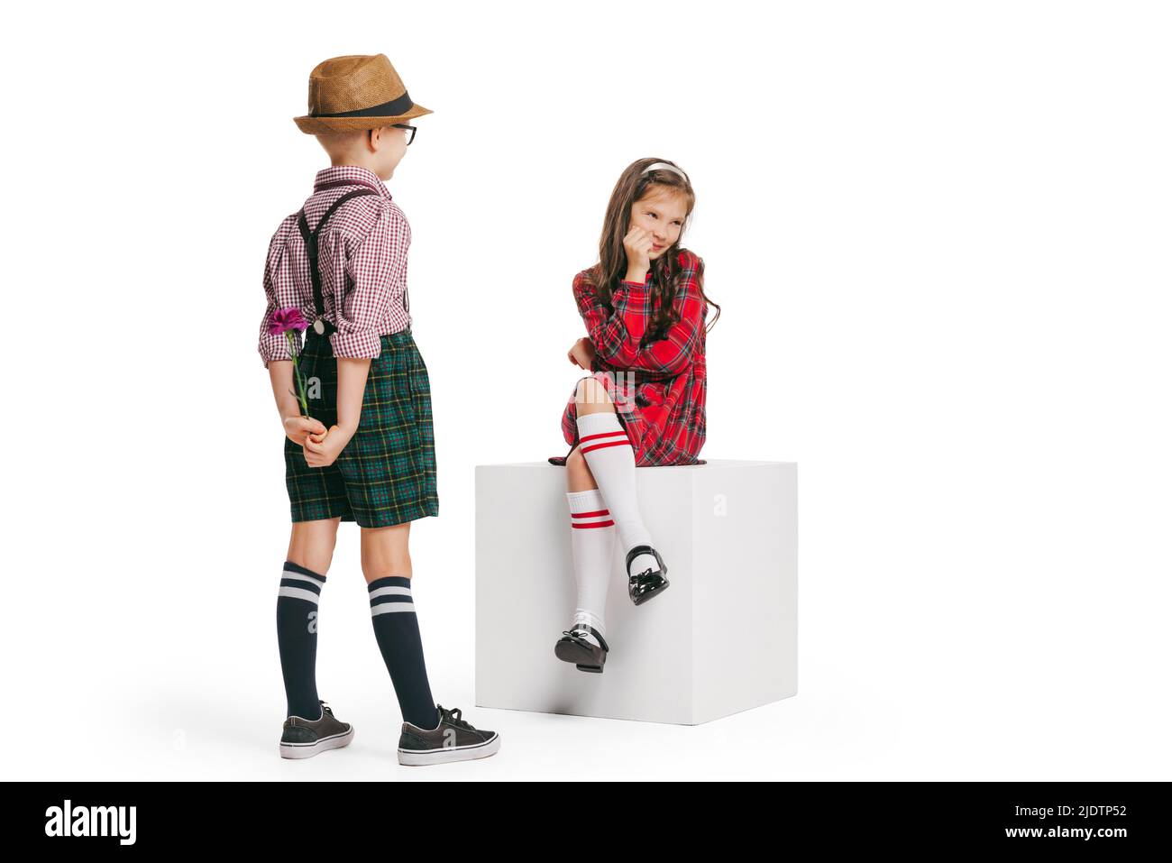 Ritratto di ragazzino e ragazza, affascinante vestito stile retrò bambini, moda di 70s, 80s anni isolato su sfondo bianco studio con spazio copia per Foto Stock