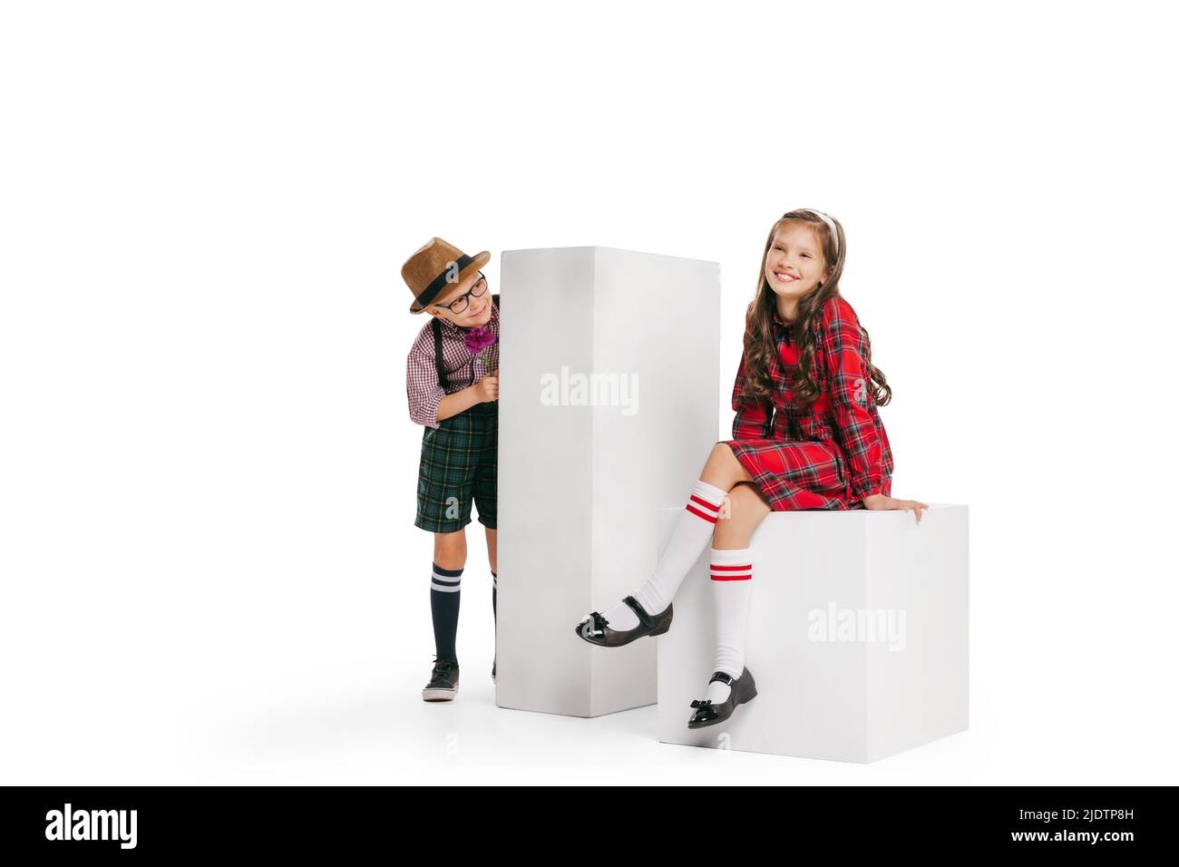 Ritratto di ragazzino e ragazza, affascinante vestito stile retrò bambini, moda di 70s, 80s anni isolato su sfondo bianco studio con spazio copia per Foto Stock