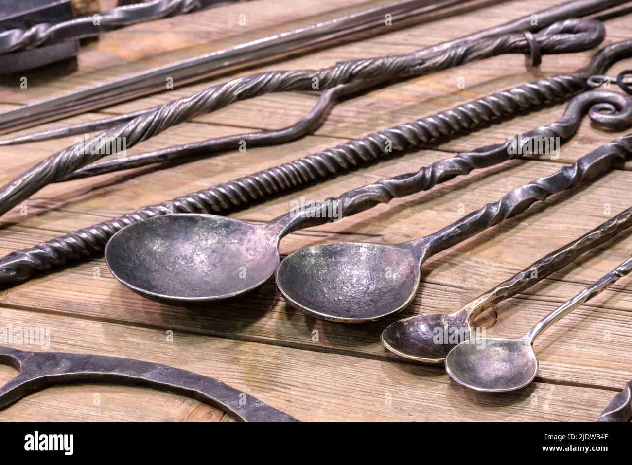 Forchette a cucchiai forgiate in stile rustico vintage e altri articoli per la casa su sfondo di legno Foto Stock