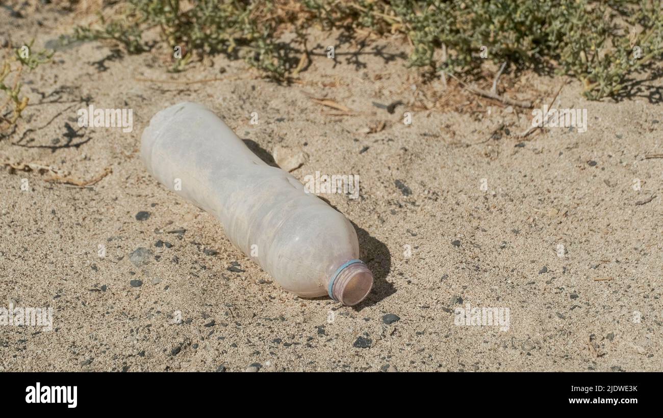 Primo piano della bottiglia di plastica nel deserto. Inquinamento plastico in deserto sabbioso. Egitto, Africa Foto Stock