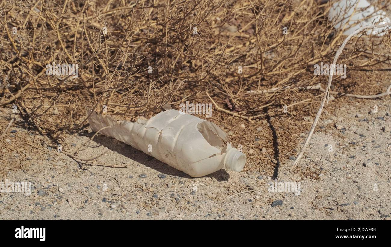 Primo piano della bottiglia di plastica nel deserto. Inquinamento plastico in deserto sabbioso. Egitto, Africa Foto Stock