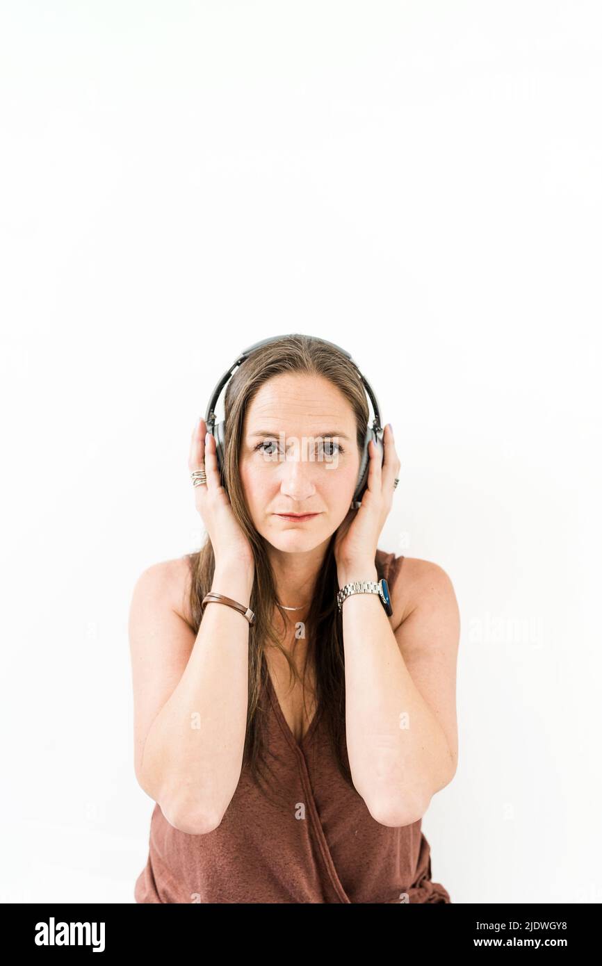 Donna con cuffie ad archetto dal look più serio Foto Stock