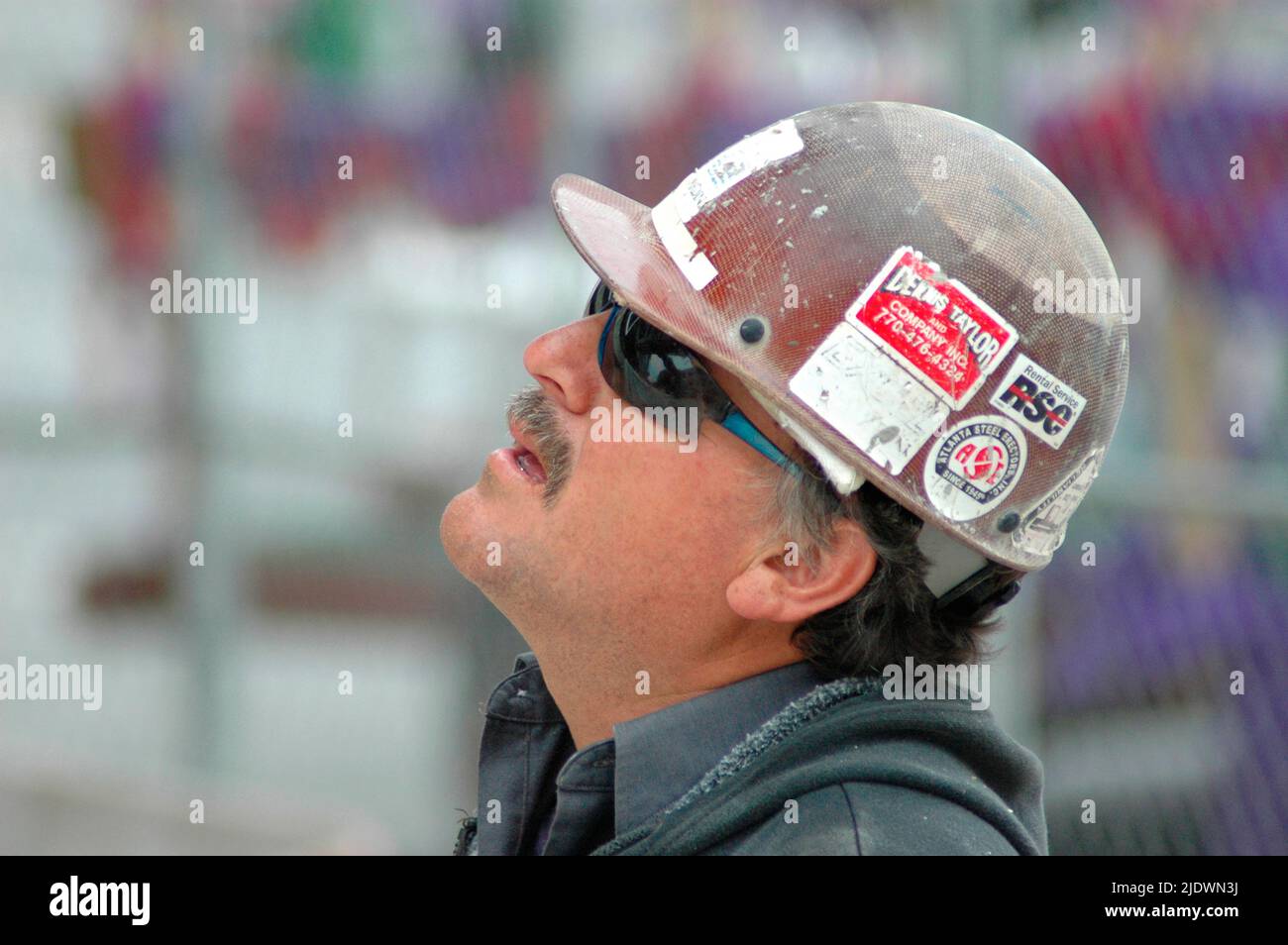 Alta costruzione di ferro e acciaio e cemento con operai in attrezzature di sicurezza al lavoro Foto Stock