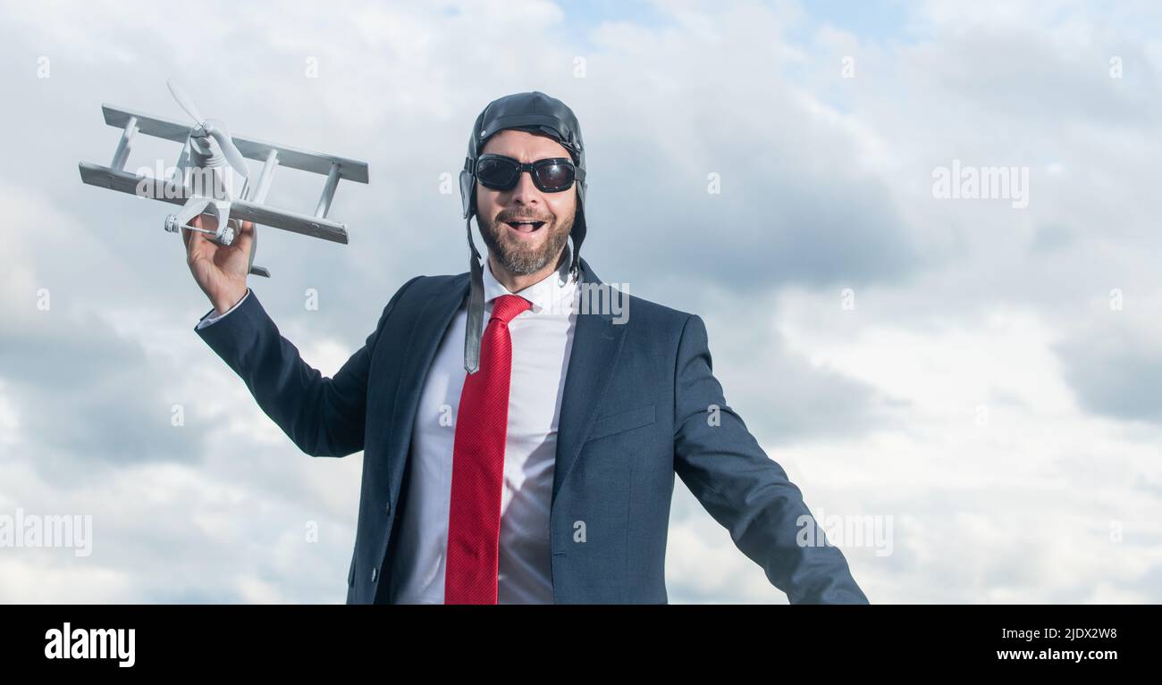 felice uomo d'affari in vestito e cappello pilota lancio aereo giocattolo Foto Stock
