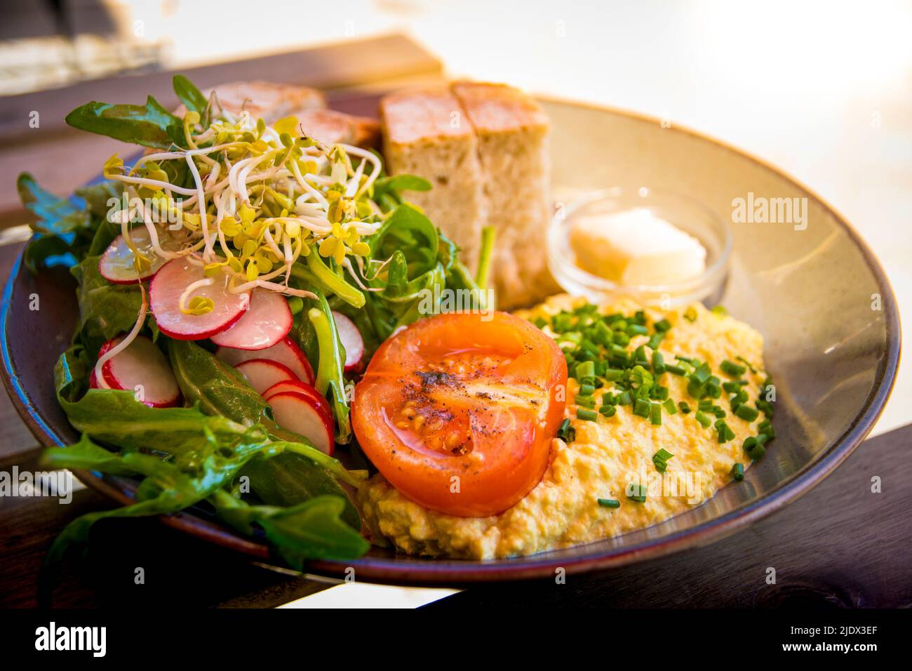 Sana colazione vegana. Tofu strapazzate come sostituzione all'uovo con pomodoro, insalata, rafano e pane e burro vegetale Foto Stock