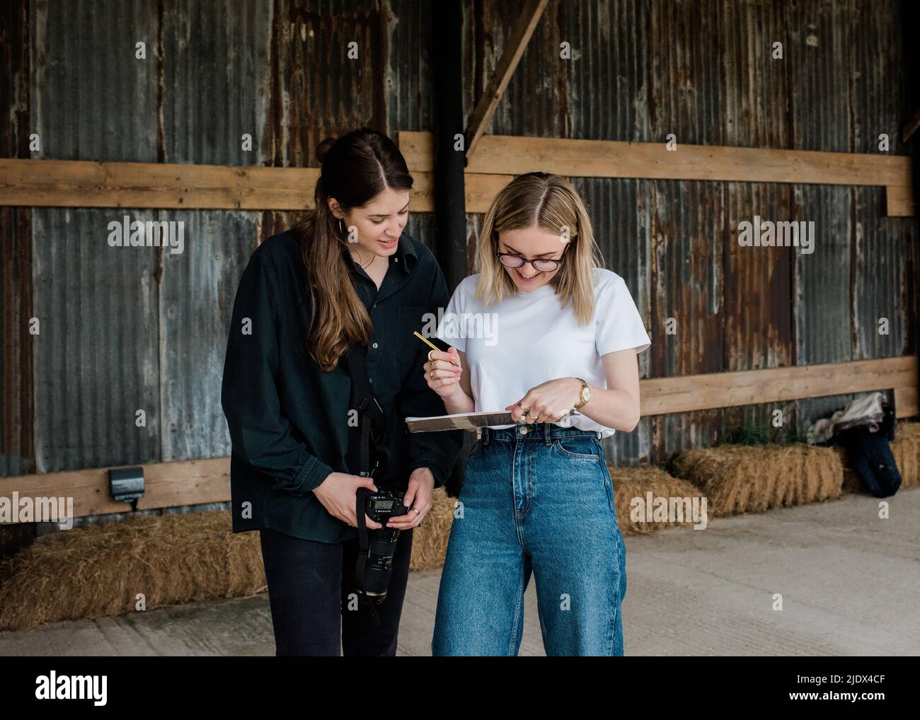 fotografo e regista che controllano l'elenco delle riprese dietro le quinte Foto Stock