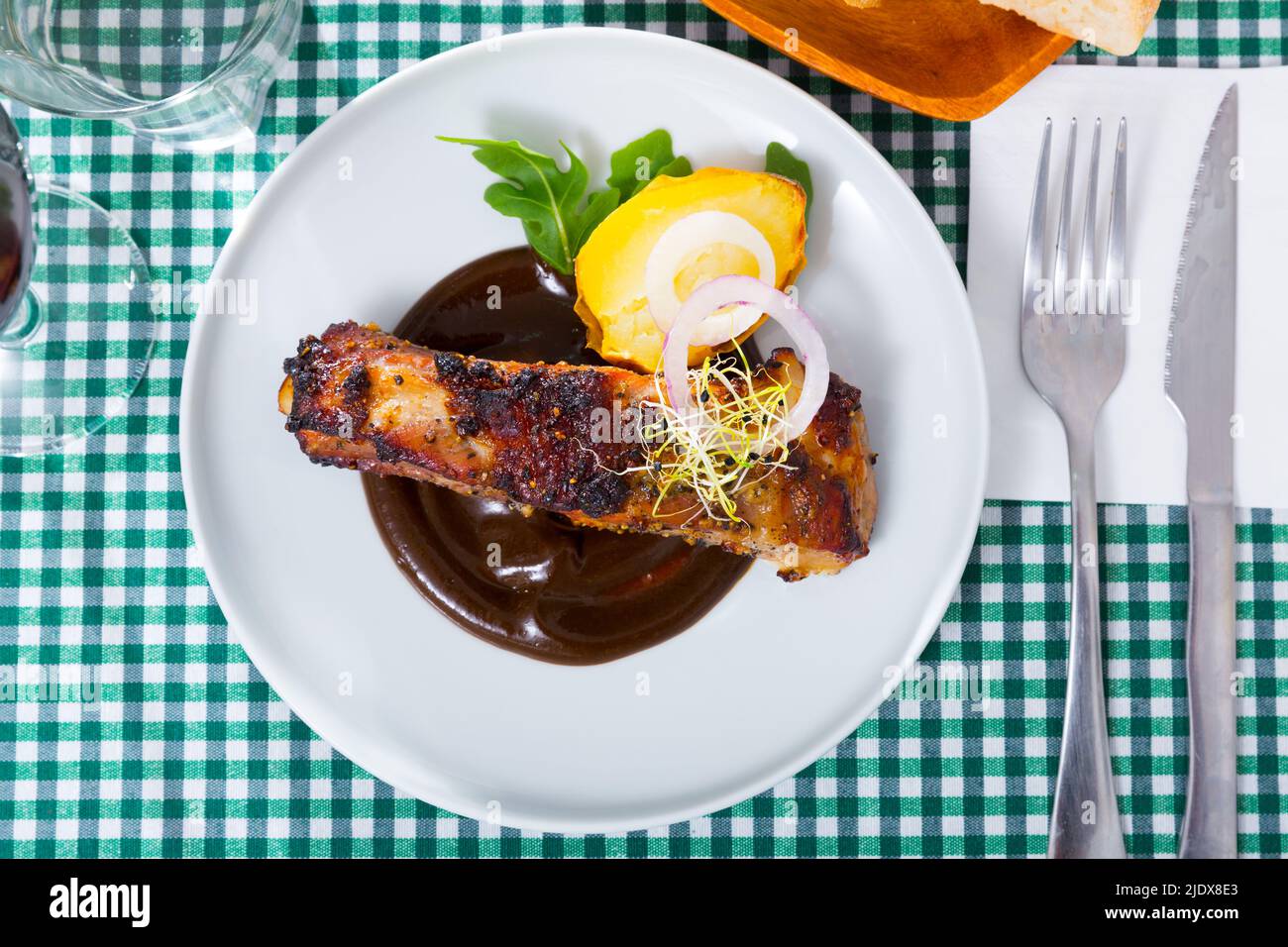 Vista dall'alto delle costolette di maiale in salsa di cioccolato con patate al forno Foto Stock