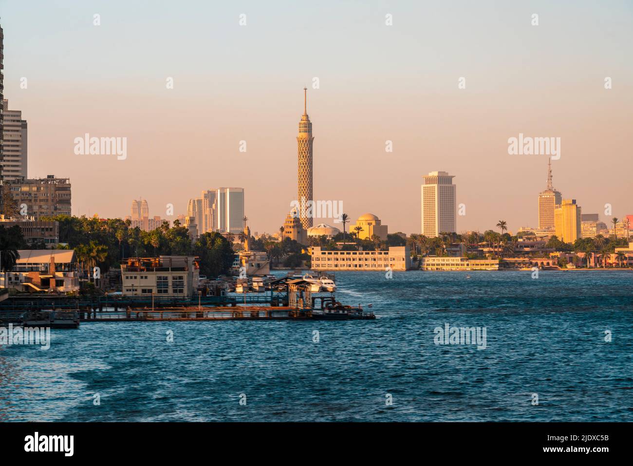 Egitto, Cairo, molo nel quartiere di Gezira al tramonto con la Torre del Cairo e lo skyline del centro in background Foto Stock