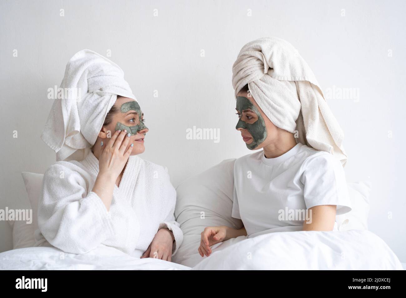 Giovani amici con maschere facciali che si guardano l'un l'altro Foto Stock