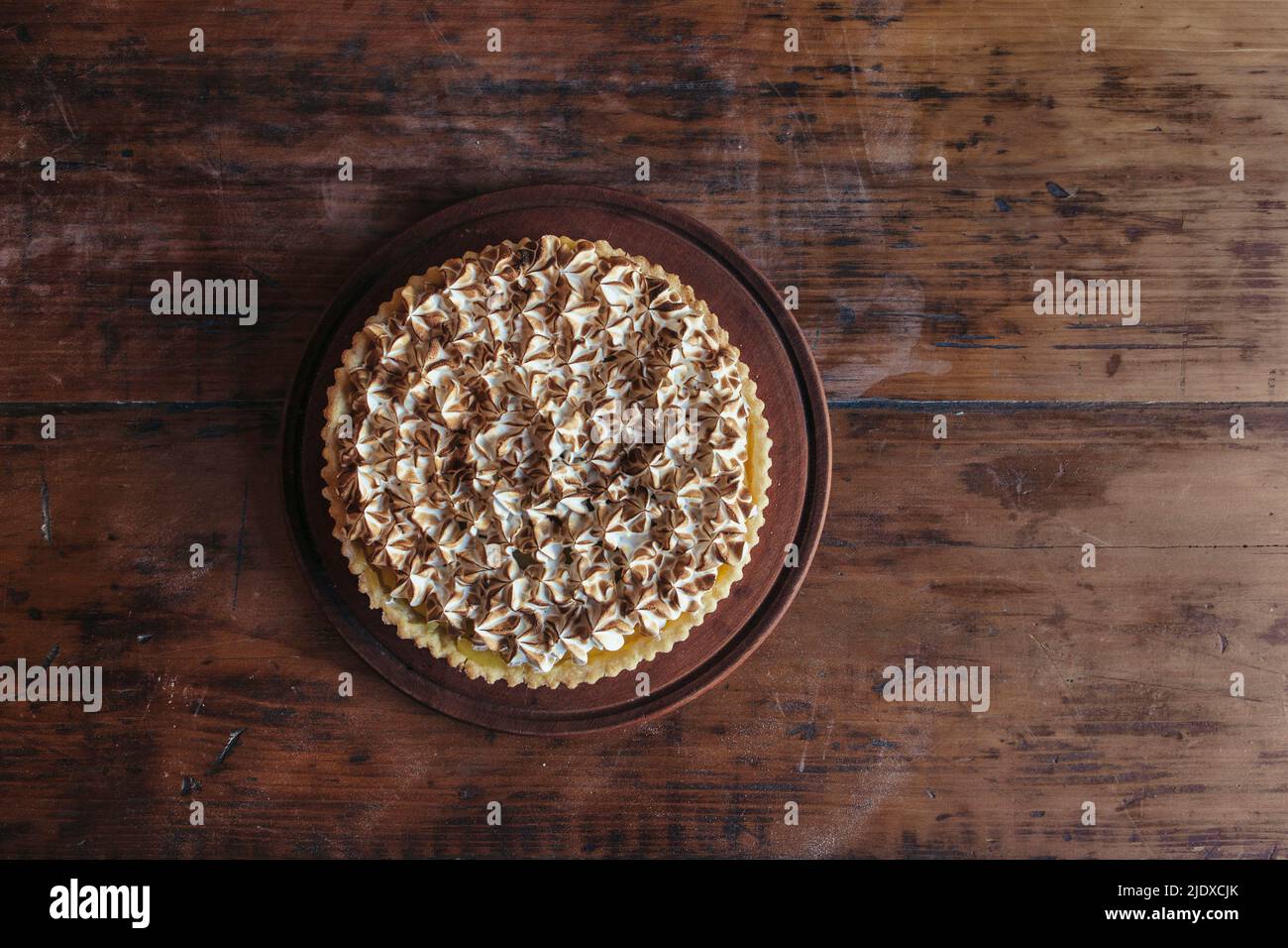 Torta di meringa fresca su tavola di legno in panetteria Foto Stock