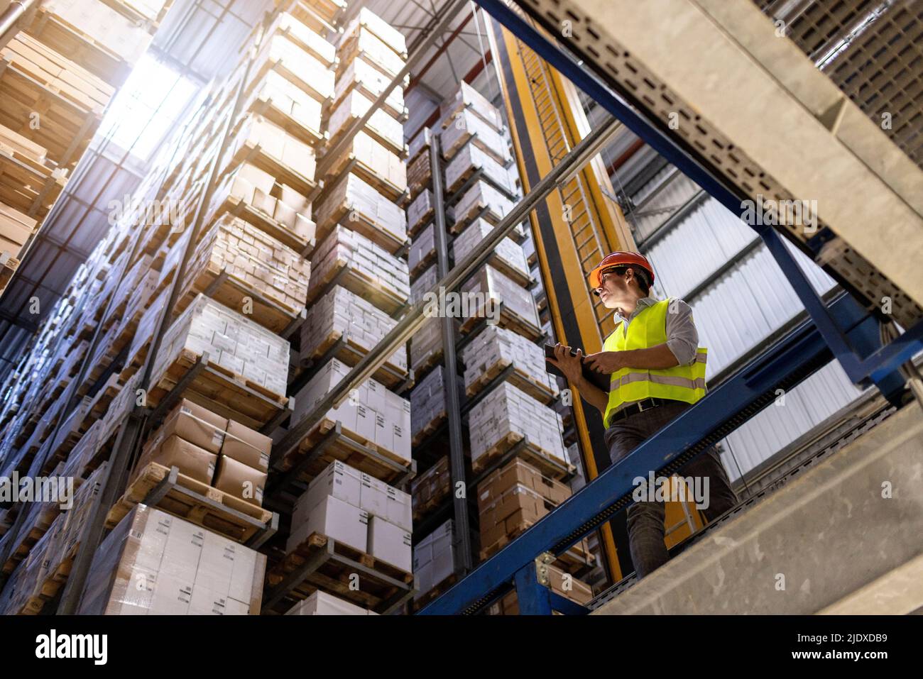 Lavoratore con PC tablet che controlla l'inventario in magazzino Foto Stock