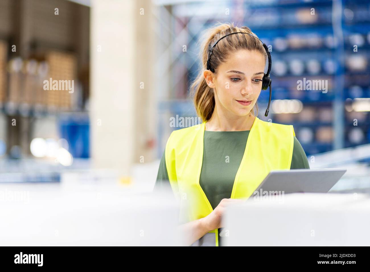 Giovane lavoratore che utilizza un tablet PC in magazzino Foto Stock