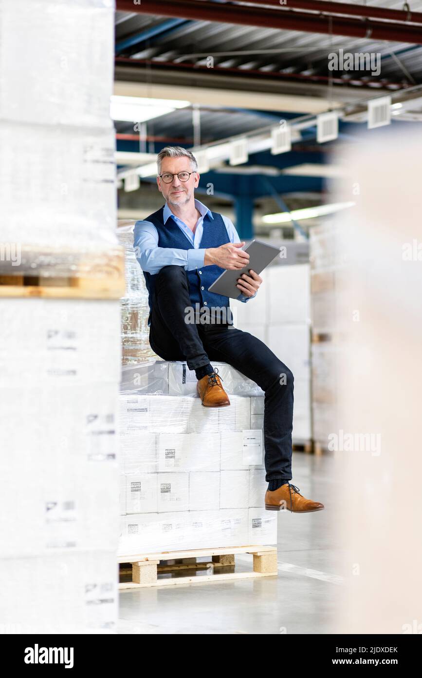Manager con PC tablet in scatole in magazzino Foto Stock