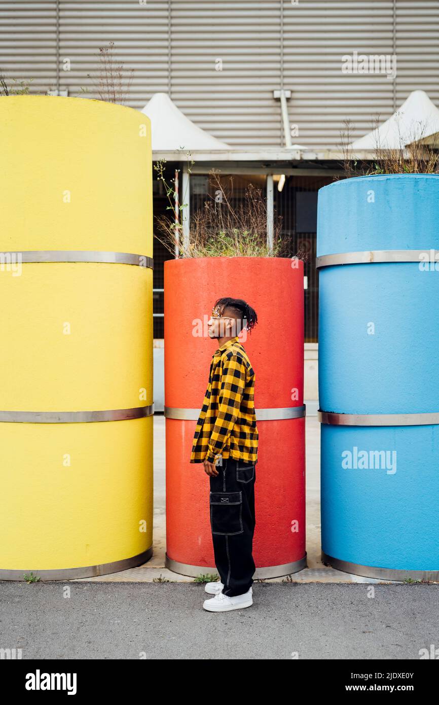Giovane uomo in piedi di fronte al tubo di cemento rosso Foto Stock