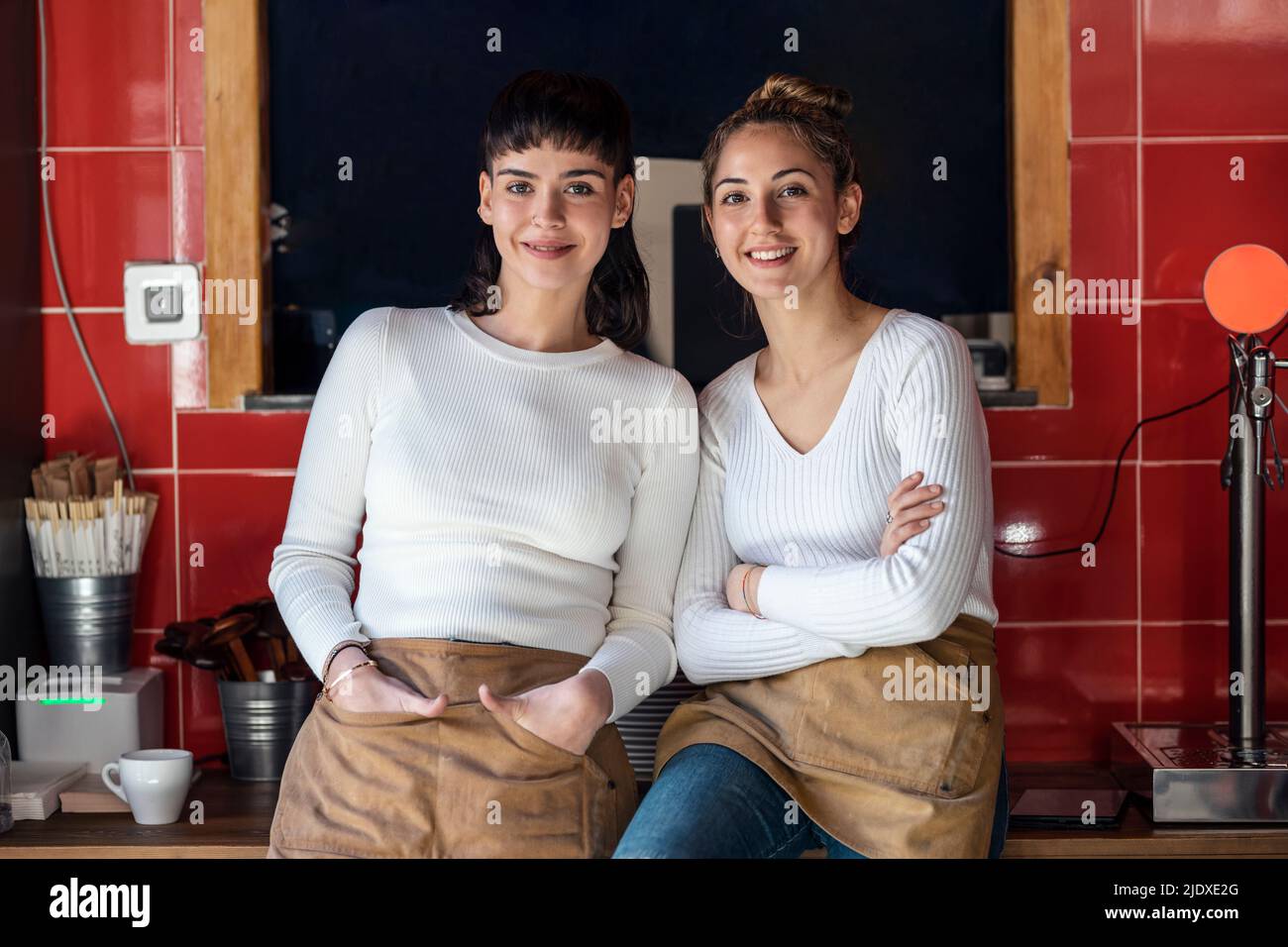 Colleghi sorridenti che indossano un grembiule al ristorante Foto Stock