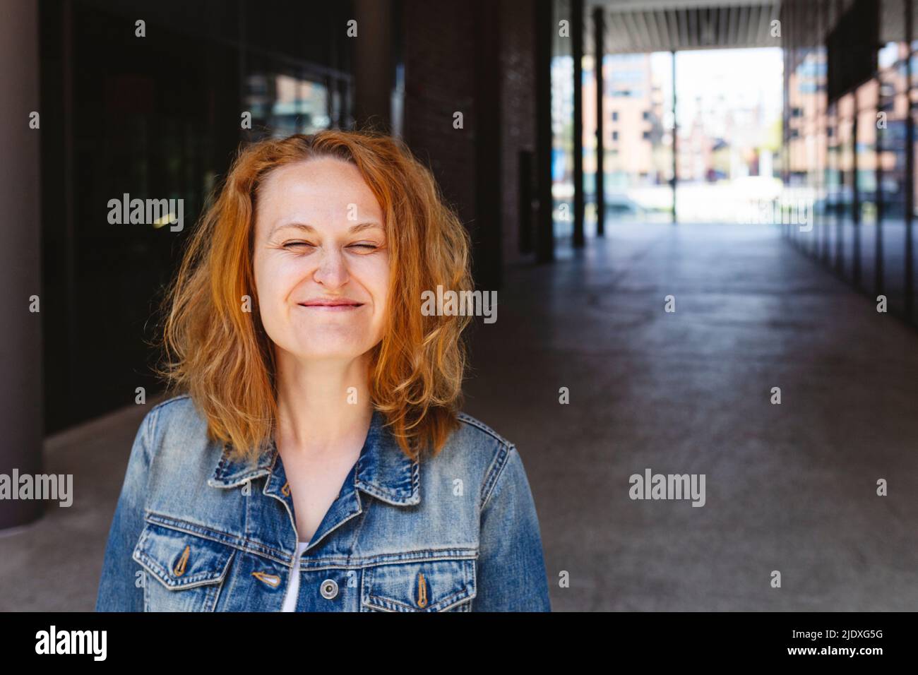 Donna sorridente che fa il viso in piedi in sala giochi Foto Stock