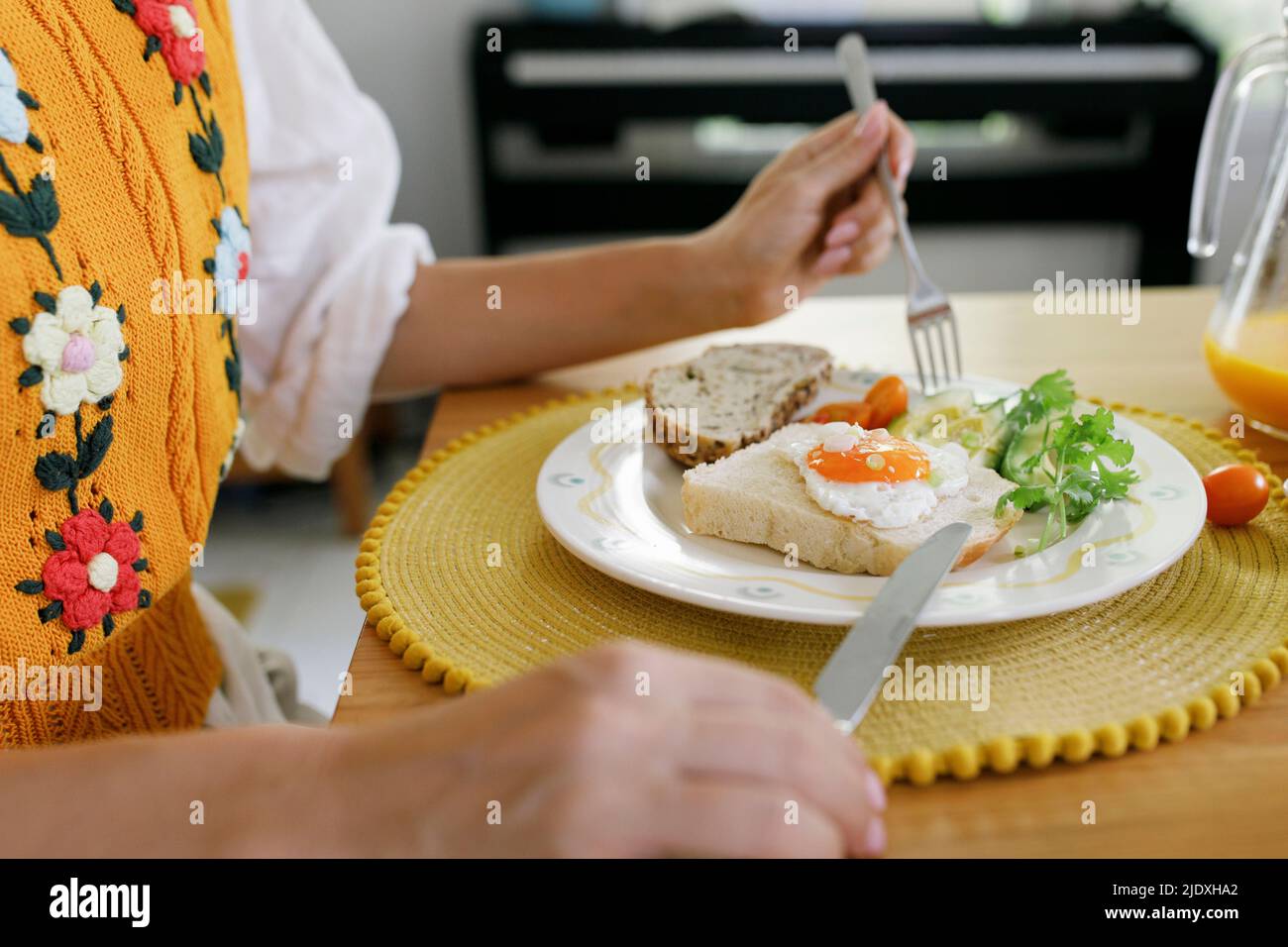 Le mani della donna che tiene il coltello da tavolo e la forcella dalla piastra sul tavolo Foto Stock