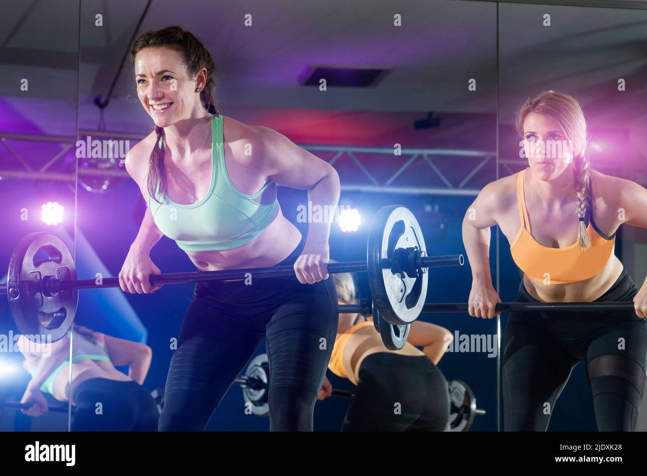 Fit donne che sollevano il campanello nella sala fitness Foto Stock