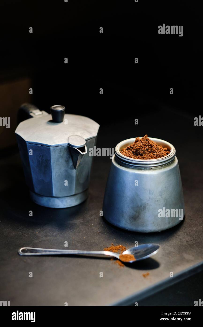 Pentola Moka e polvere di caffè in vaso sul tavolo Foto Stock