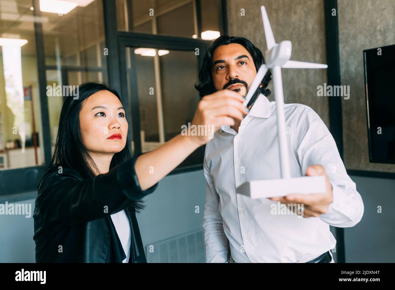 Business People analisi del modello di turbine eoliche in ufficio Foto Stock