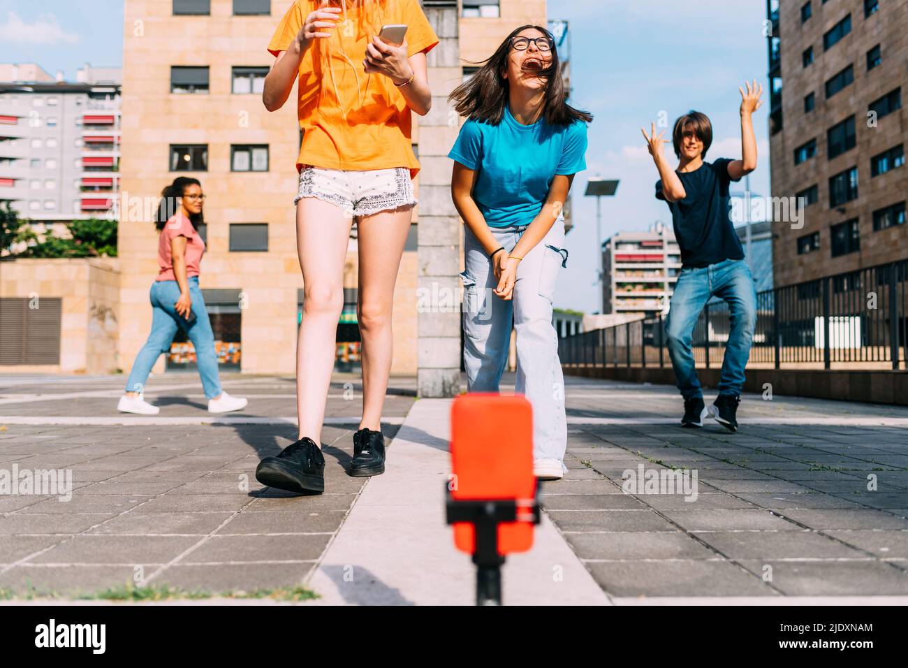 Ragazza allegra con amici che hanno vlogging divertente il giorno di sole Foto Stock
