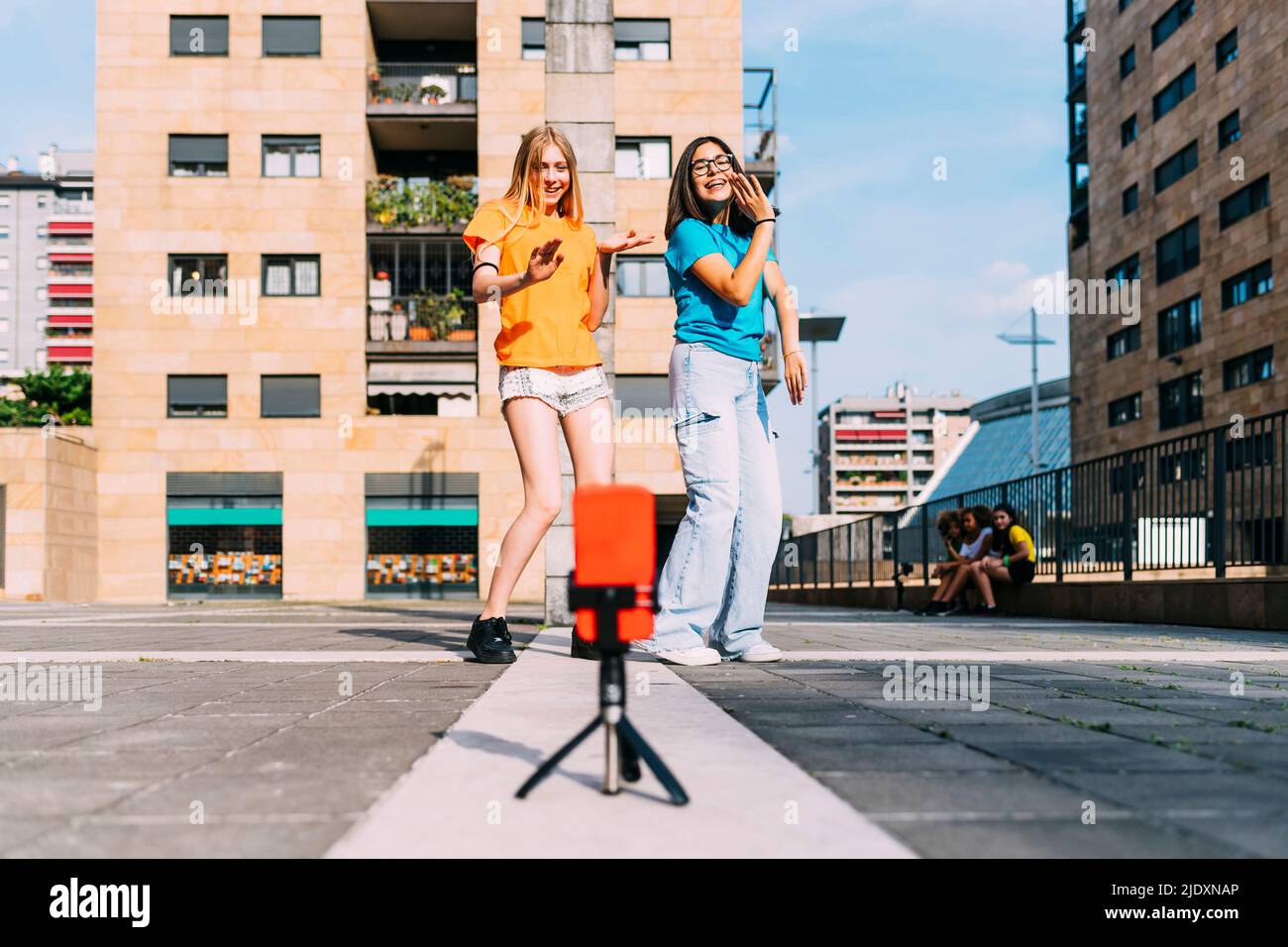 Le ragazze felici che ballano filmando con il telefono cellulare in giorno di sole Foto Stock