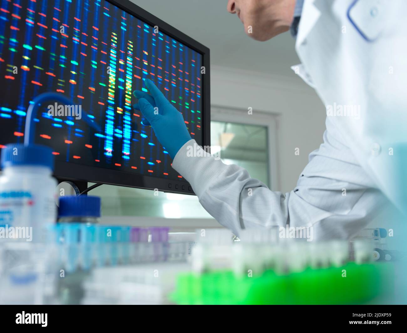 Scienziato che analizza il DNA sullo schermo del computer in laboratorio Foto Stock