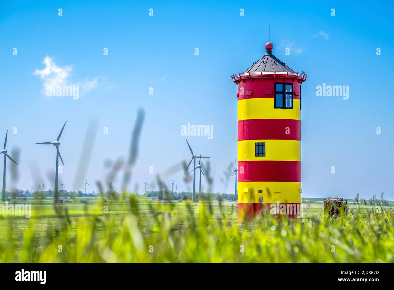Germania, bassa Sassonia, Krummhorn, Pilsum Faro in primavera con vento fattoria sullo sfondo Foto Stock