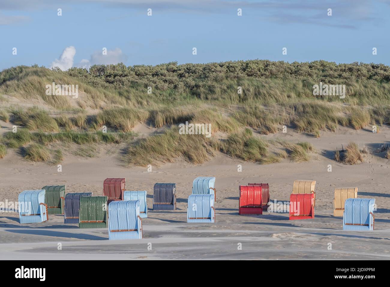 Germania, bassa Sassonia, Juist, sdraio con cappuccio di fronte a dune erbose Foto Stock