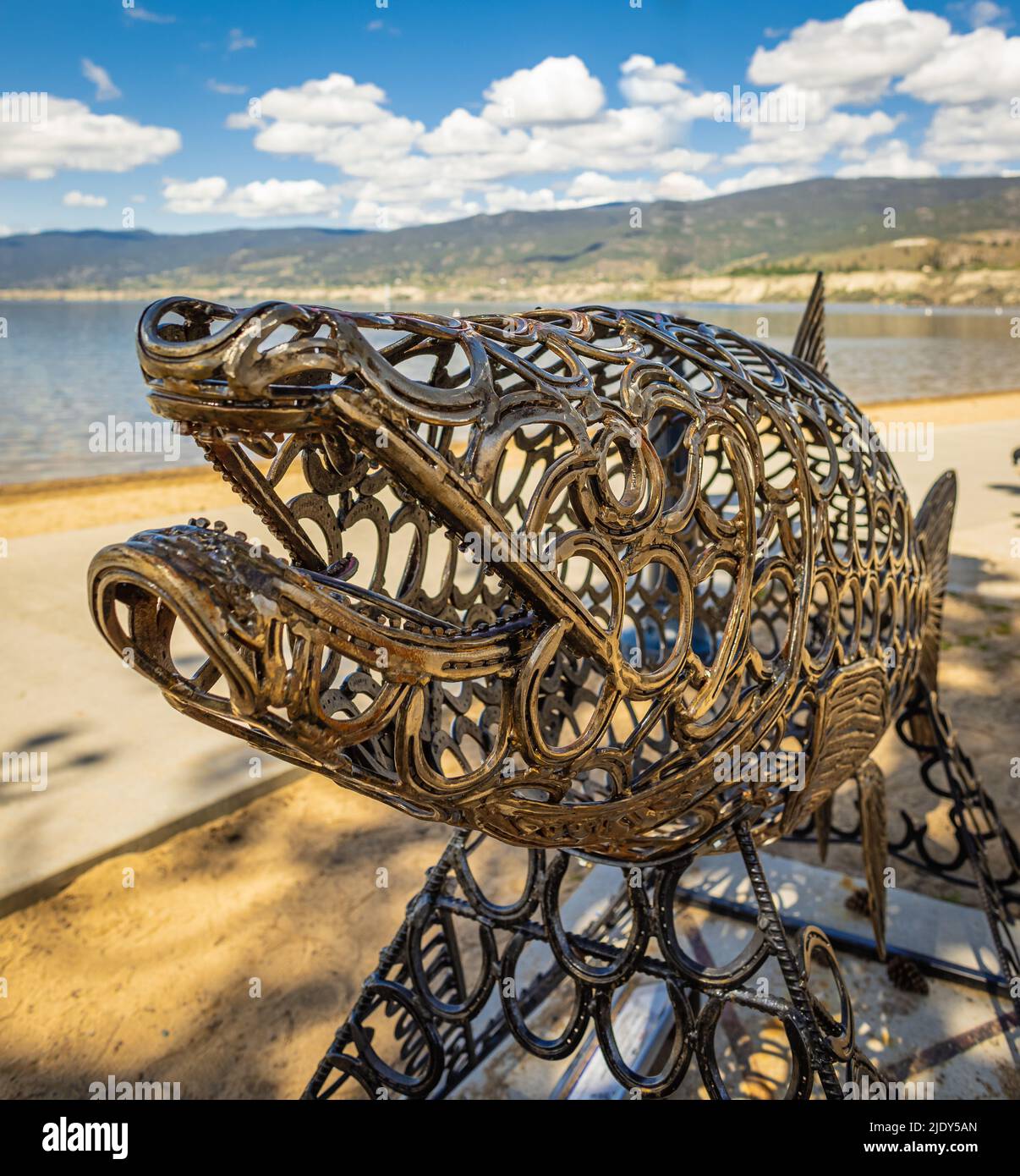 Scultura in metallo di pesce su una spiaggia di Penticton BC Canada. Oggetto d'arte a forma di pesce di salmone Foto Stock