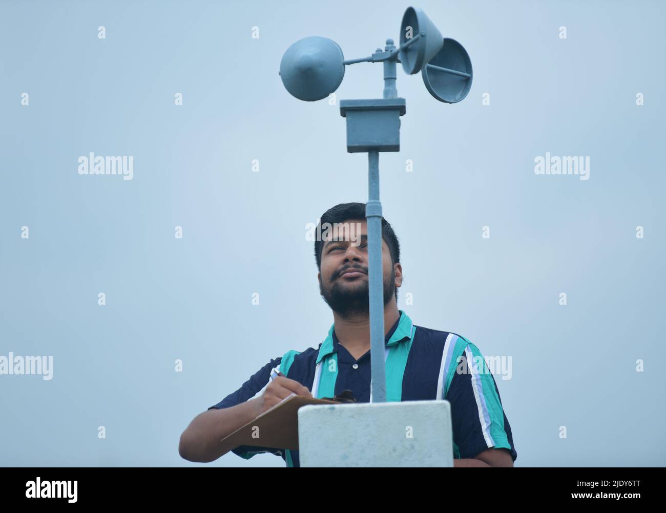 Un funzionario del Dipartimento Meteorologico dell'India prende la lettura e le informazioni da un anemometro sulla velocità del vento e la pressione del vento al Centro Meteorologico di Agartala. Global Wind Day o World Wind Day è un evento mondiale che si tiene il 15th giugno in tutto il mondo per celebrare l'energia eolica. Agartala, Tripura, India. Foto Stock