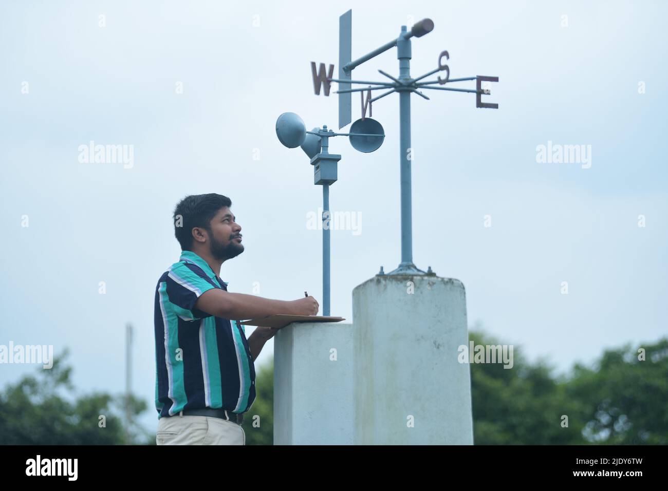 Un funzionario del Dipartimento Meteorologico dell'India prende la lettura e le informazioni da un anemometro sulla velocità del vento e la pressione del vento al Centro Meteorologico di Agartala. Global Wind Day o World Wind Day è un evento mondiale che si tiene il 15th giugno in tutto il mondo per celebrare l'energia eolica. Agartala, Tripura, India. Foto Stock