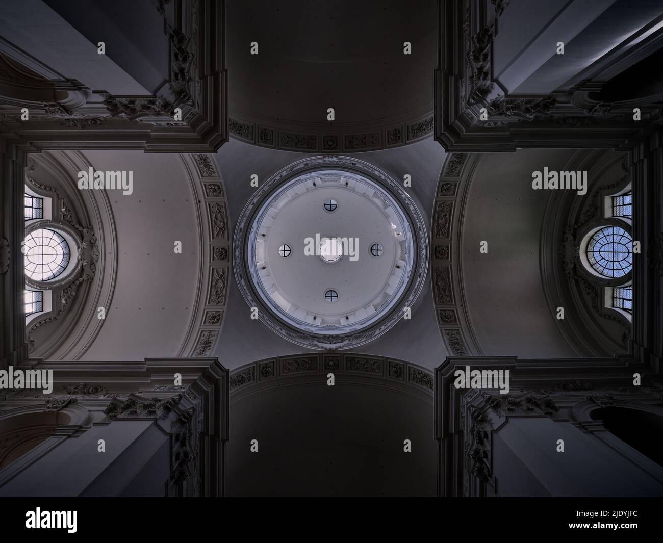 Soffitto simmetrico della chiesa barocca con cupola e lucernario circolare a Salisburgo, Austria, che mostra un'elegante architettura storica sacra. Foto Stock
