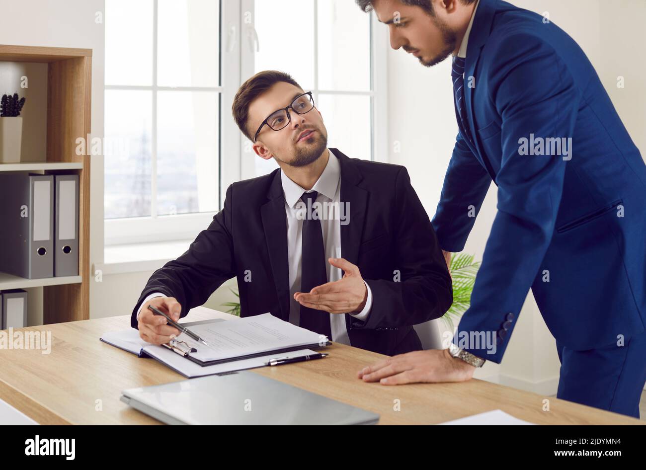 Agente assicurativo o avvocato che dà consultazione al giovane durante la loro riunione in carica Foto Stock