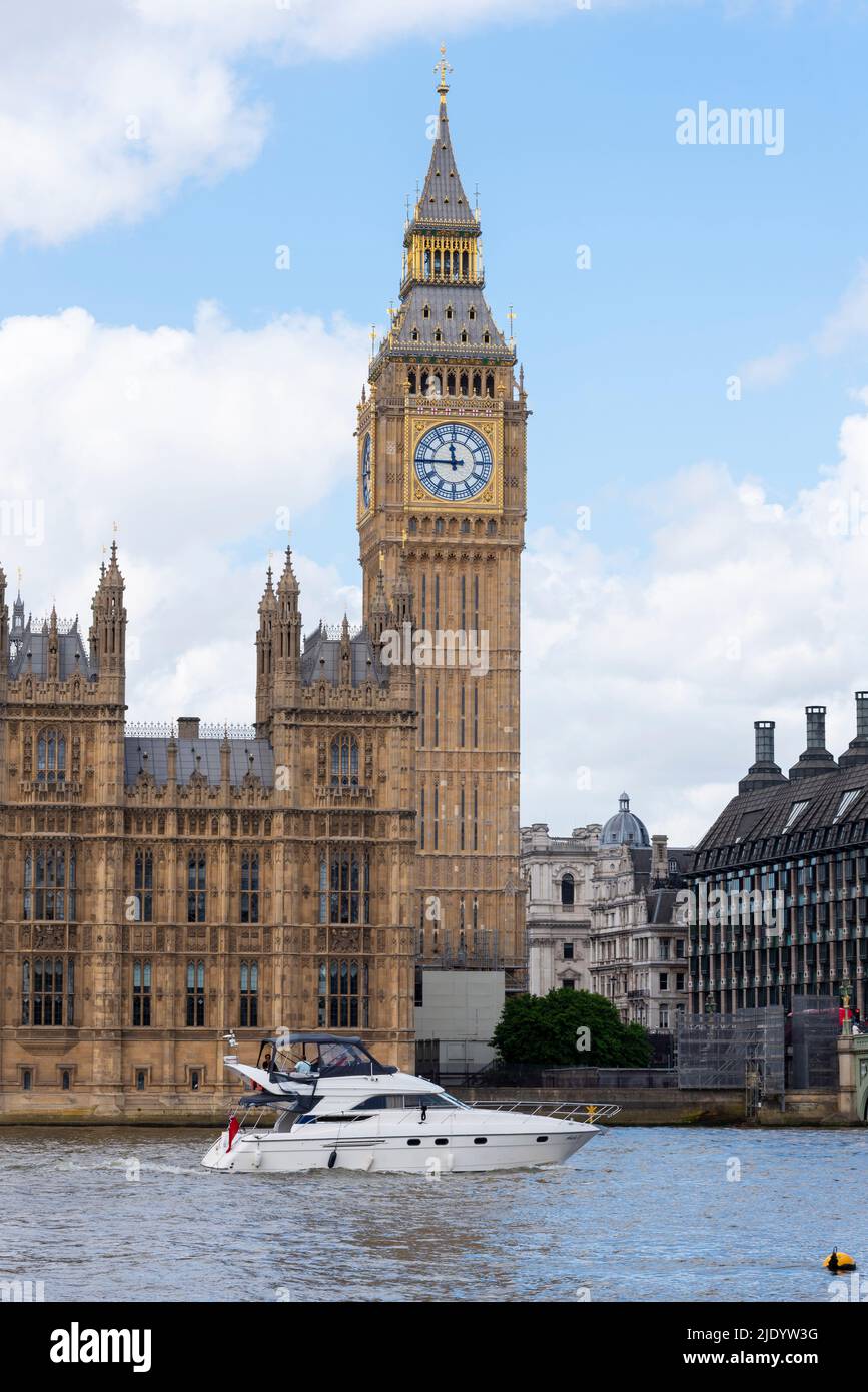 Elizabeth Tower, Big ben, del Palazzo di Westminster, con un motoscafo Princess 440 che passa sul Tamigi. Traffico fluviale privato di Londra Foto Stock