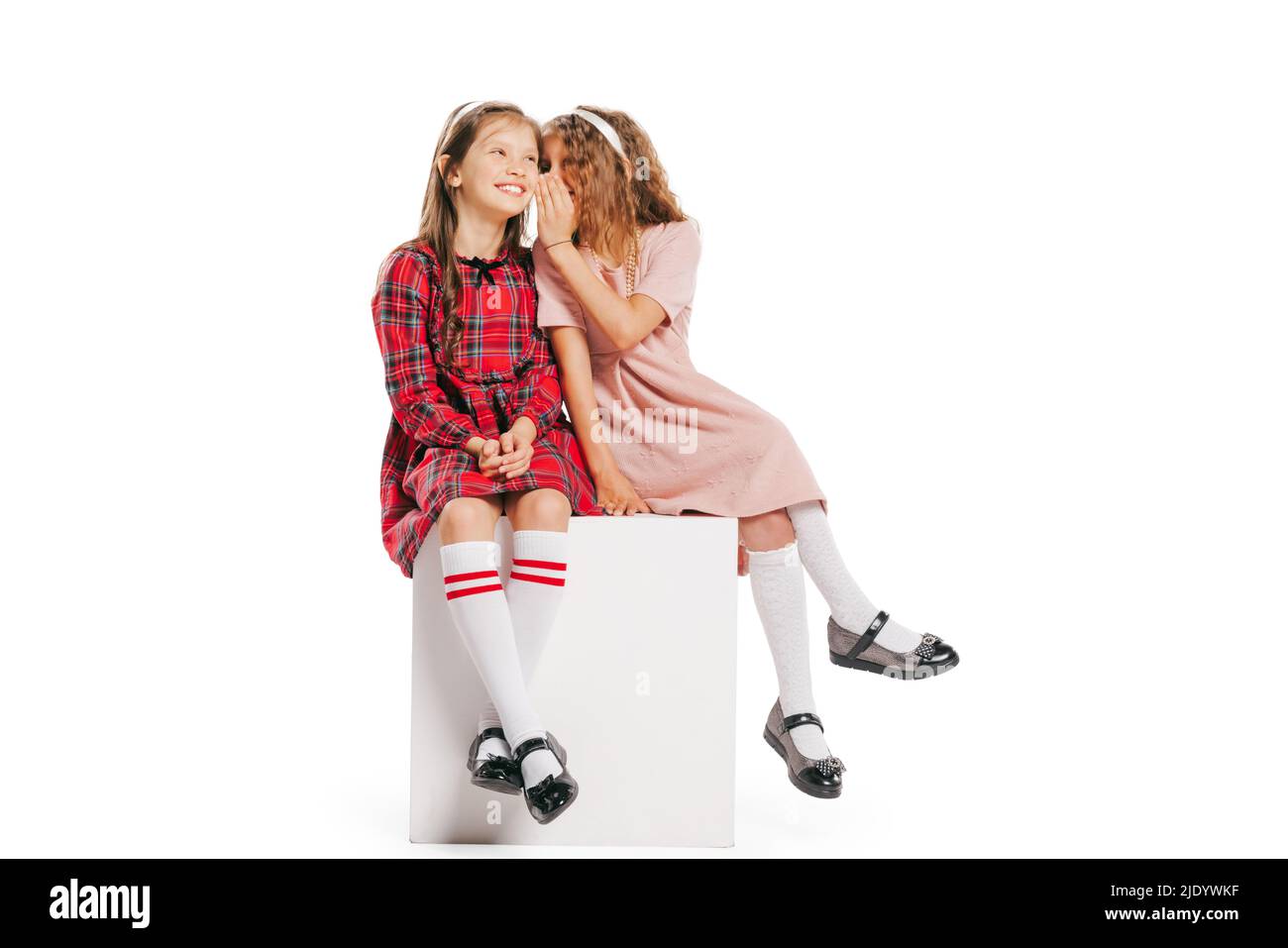Studio girato di piccole ragazze felice in stile retrò vestito, moda di 70s, 80s anni isolato su sfondo bianco. Concetto di arte, amicizia, speranza Foto Stock