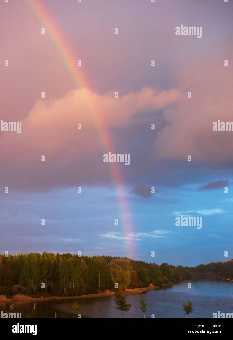 Paesaggio con grande arcobaleno nel cielo al tramonto Foto Stock