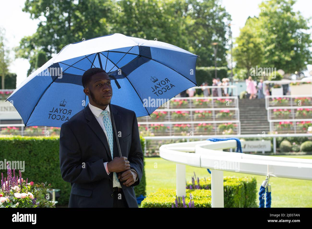 Ascot, Berkshire, Regno Unito. 17th giugno 2022. Una steward all'ippodromo di Ascot cerca di rimanere fresco sotto un ombrello in una giornata calda bollente. Credit: Maureen McLean/Alamy Foto Stock