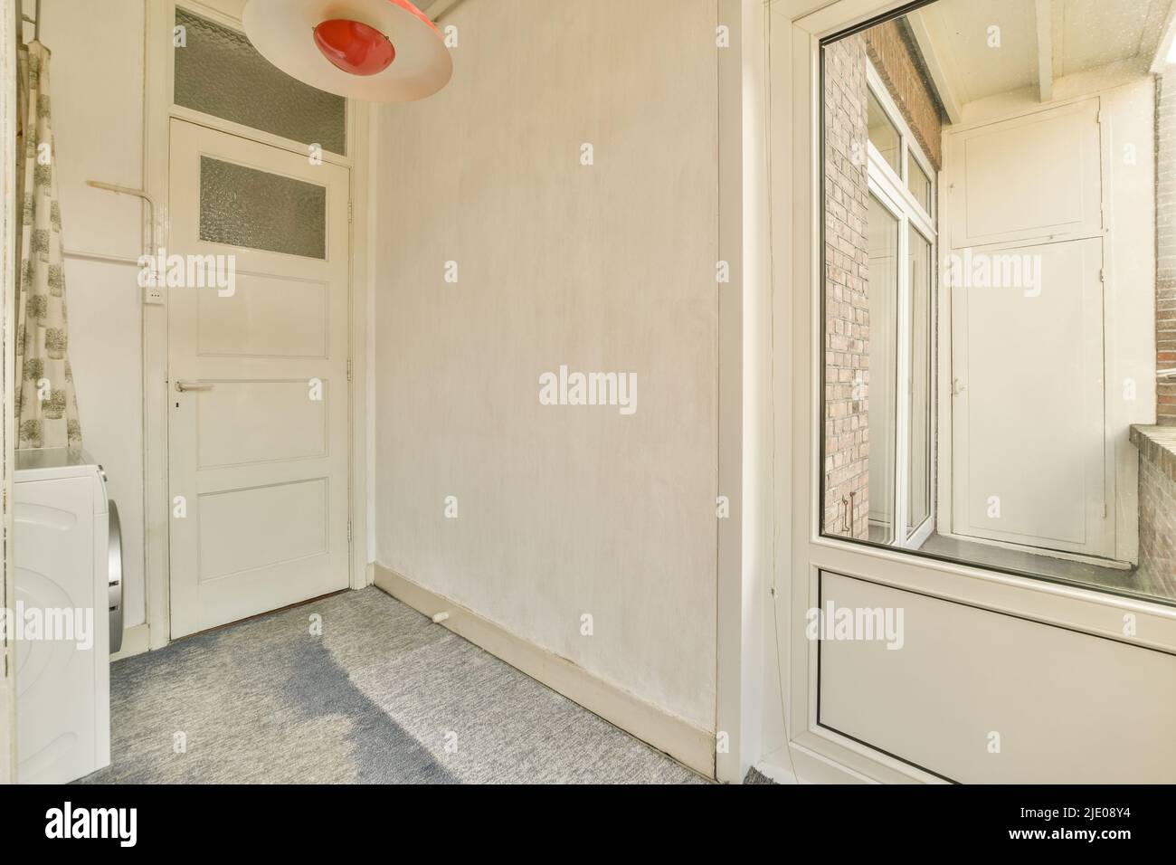 Camera spaziosa, luminosa e vuota con armadio e lavatrice, realizzata in stile minimalista Foto Stock