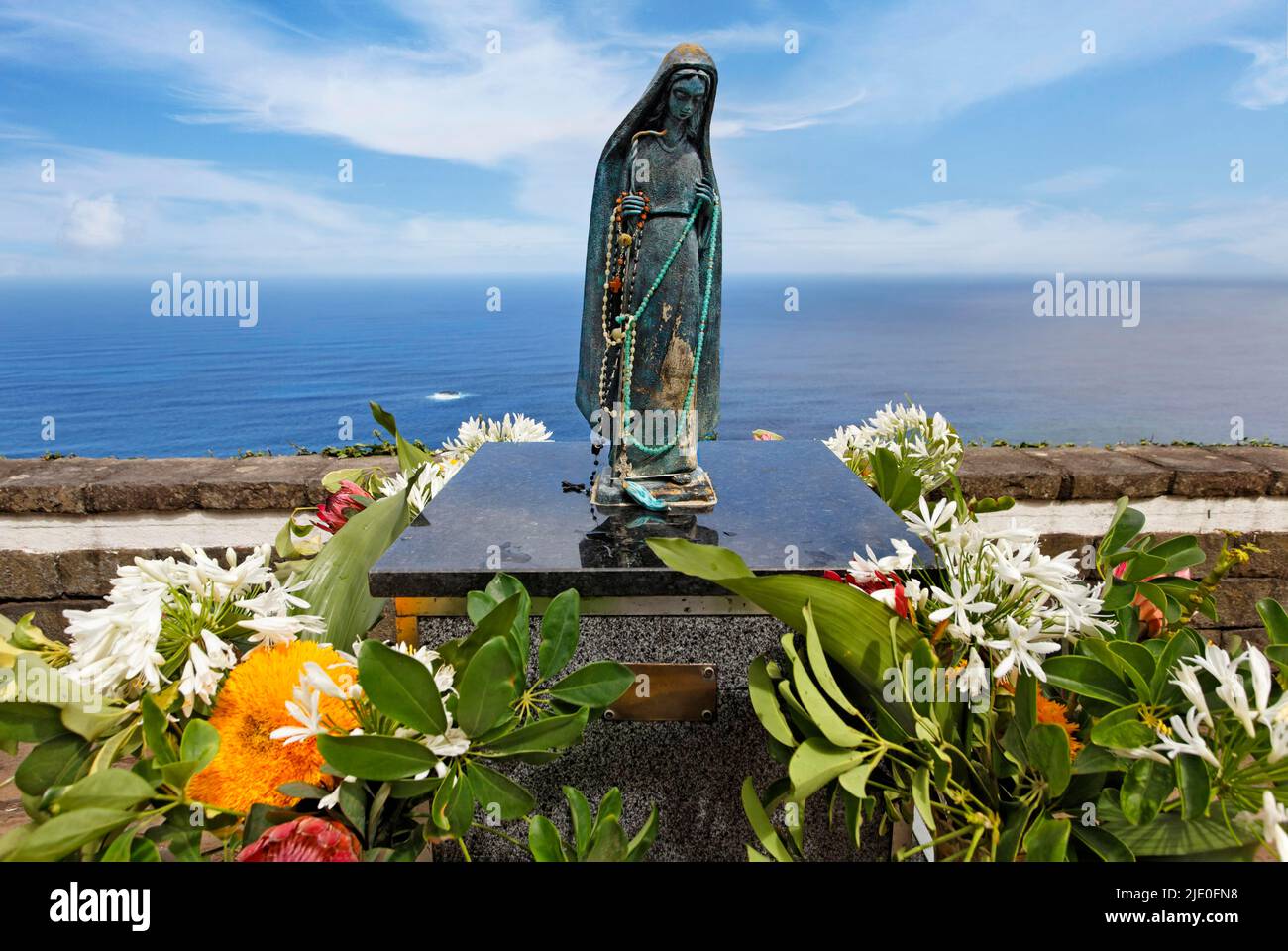 Piccola statua Vergine Maria, rosario, fiori vari, muro, mare posteriore, Roadside, Madeira, ufficialmente Regione Autonoma di Madeira, isola, Atlantico Foto Stock