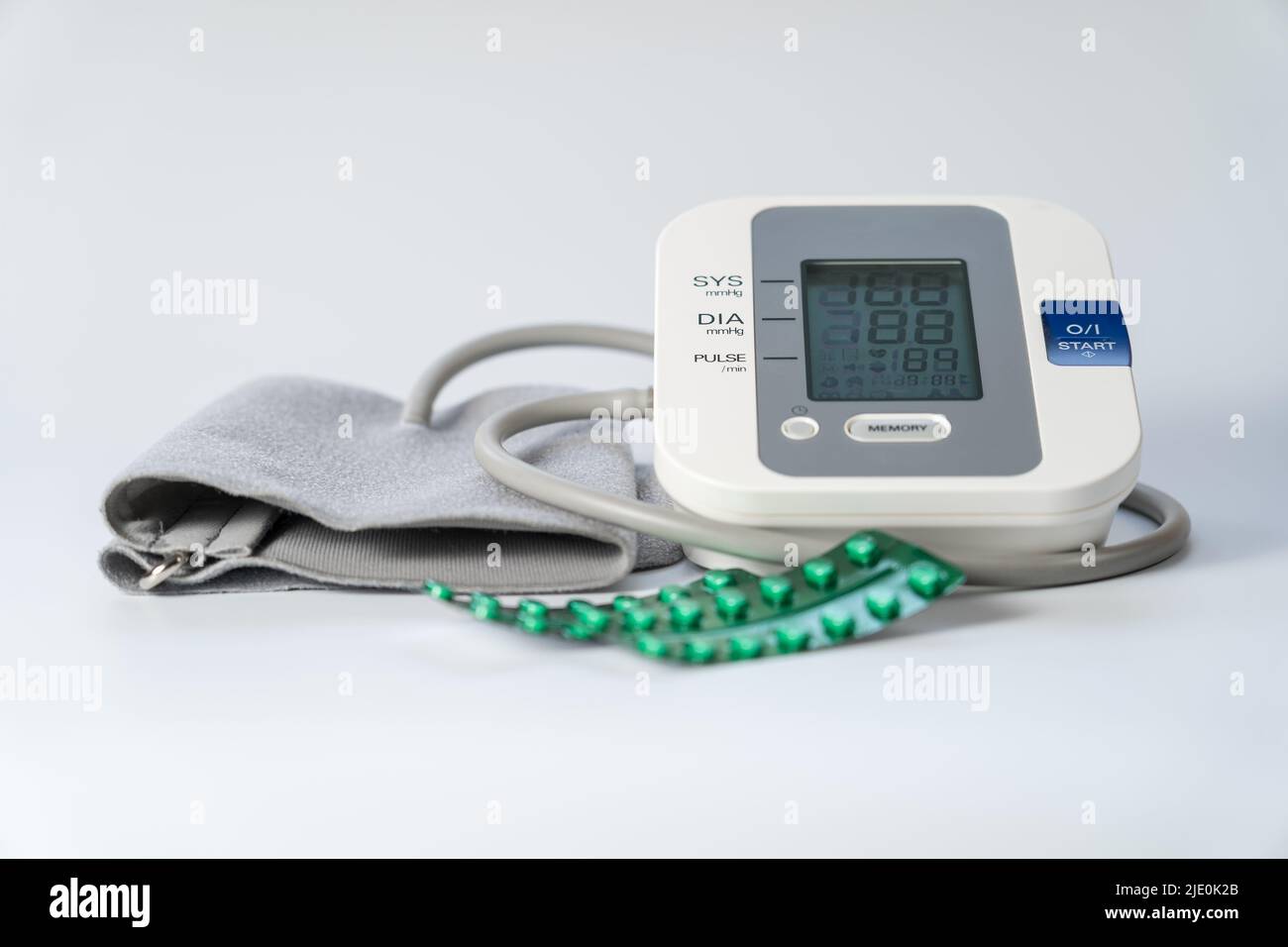 Monitor della pressione sanguigna per prendere la pressione sanguigna e pillole per abbassarla. Foto Stock