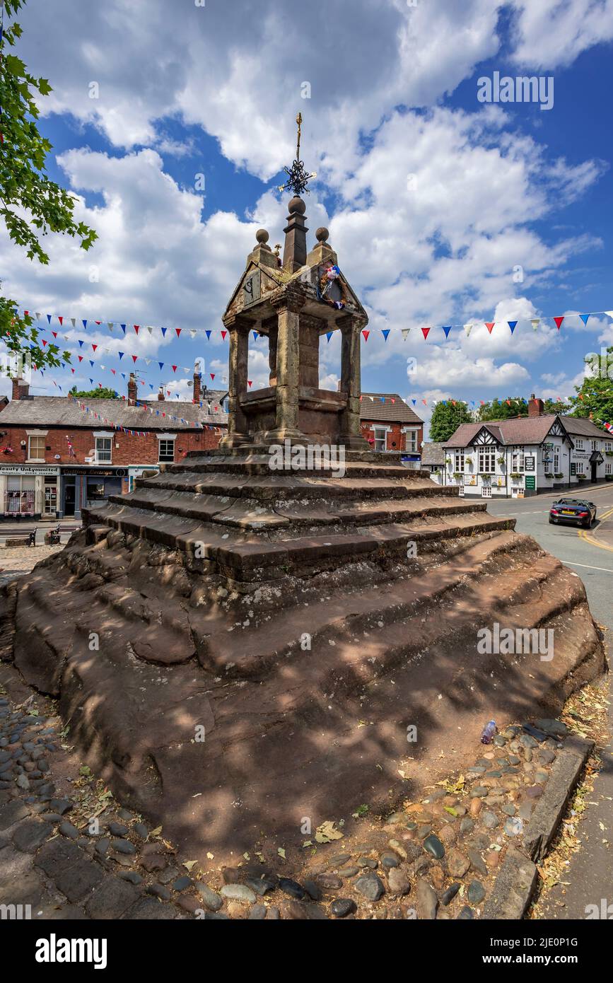 Lymm Cross nel centro del villaggio di Lymm, Warrington, Cheshire, registrato nella Lista del Patrimonio Nazionale per l'Inghilterra come una lista designata di grado I. Foto Stock