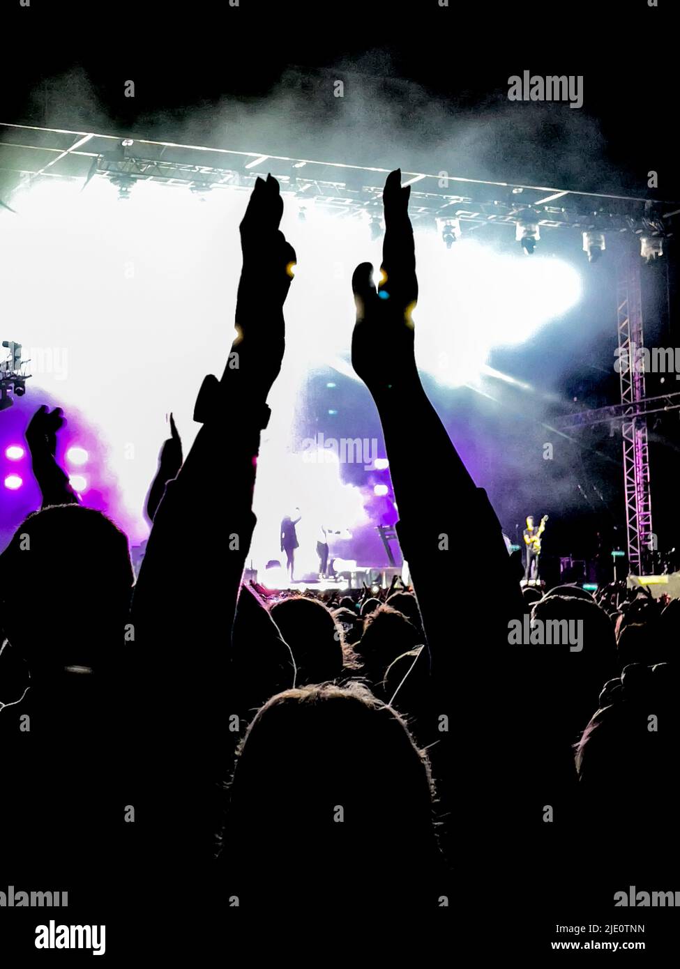 La folla si è esibita in un concerto di musica con il palco sullo sfondo. Foto Stock