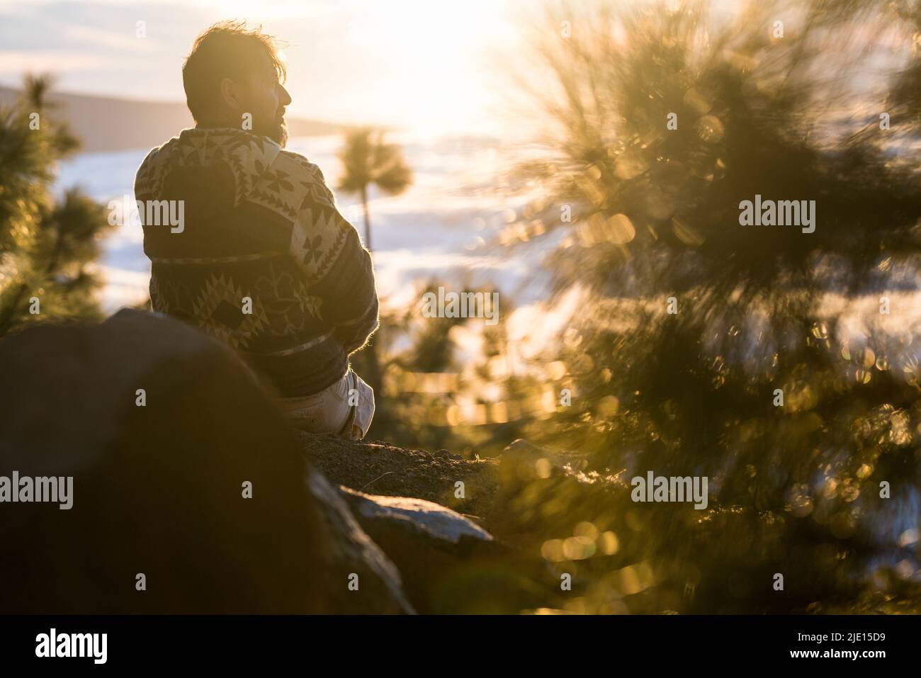 Concetto di persone e stile di vita all'aperto della natura - uomo seduto sulle rocce e godere di splendidi tramonti e paesaggi in background - montagna turismo h Foto Stock