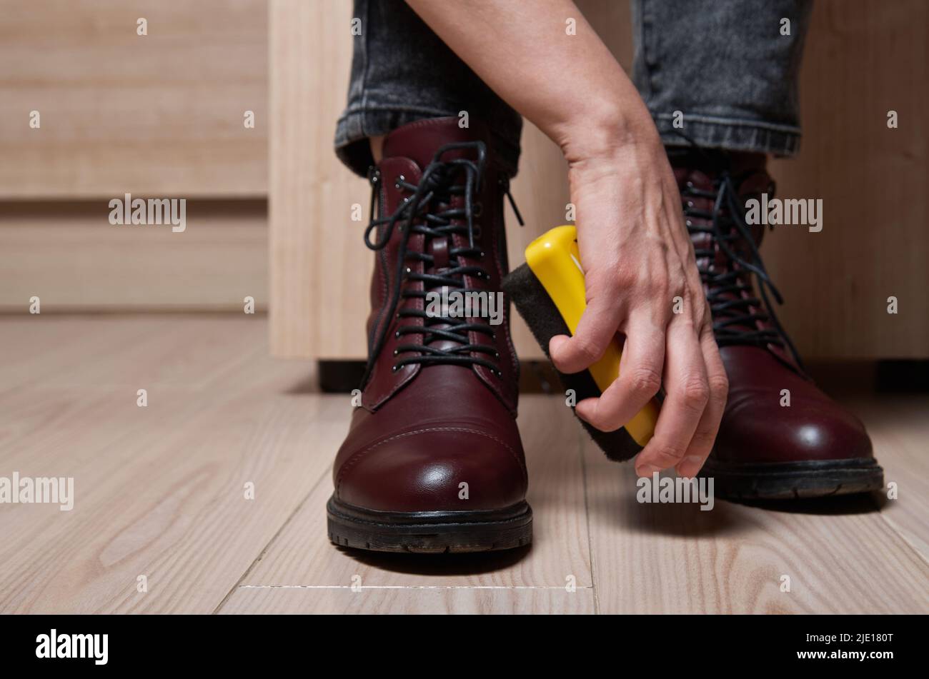 Donna che pulisce le proprie scarpe. Foto Stock