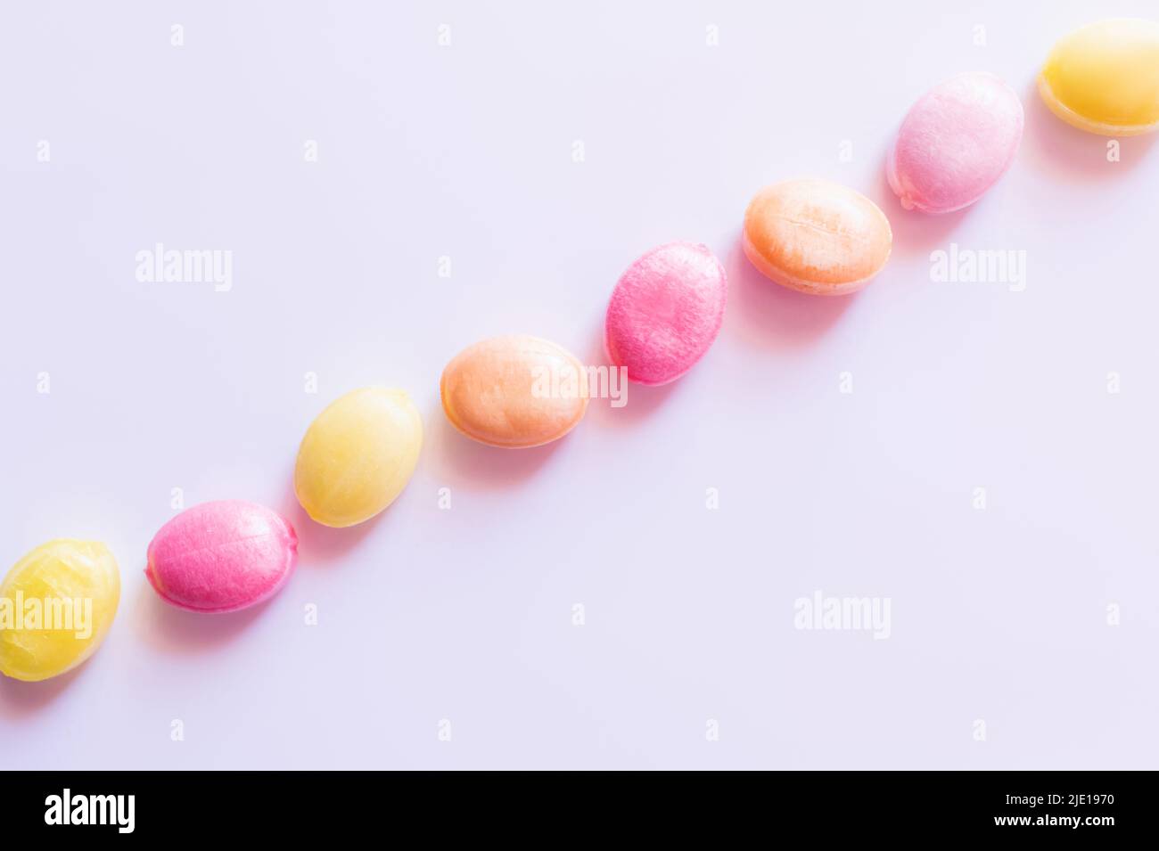 Piatto con caramelle colorate su sfondo bianco Foto Stock