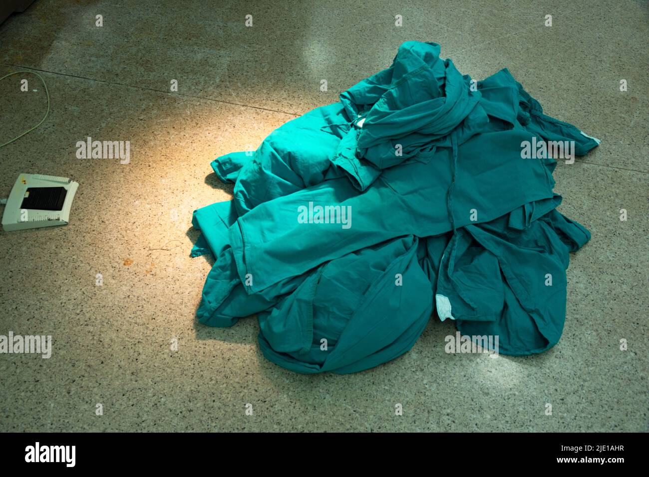 Camici chirurgici dopo l'intervento chirurgico sul pavimento in sala operatoria Foto Stock