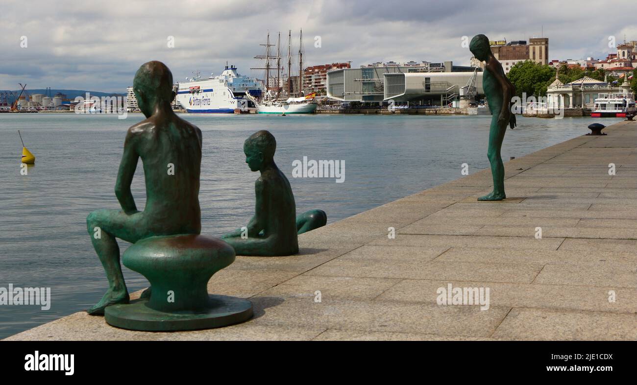 La scultura in bronzo di Los Raqueros con la nave da addestramento della Marina spagnola JUAN Sebastián DE ELCANO ancorata nella baia di Santander Cantabria Spagna Foto Stock